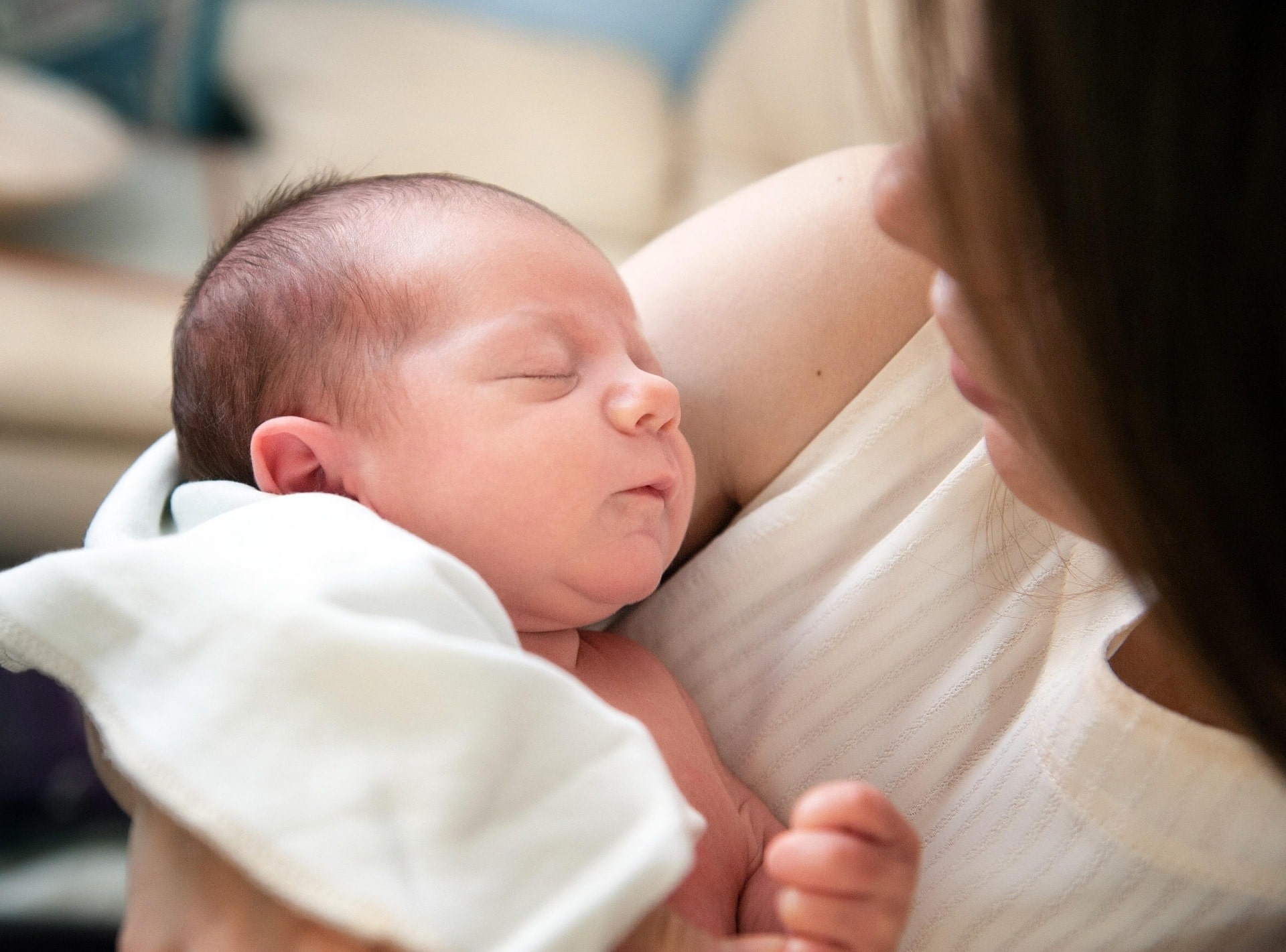 Junge Mutter mit einem Baby im Arm