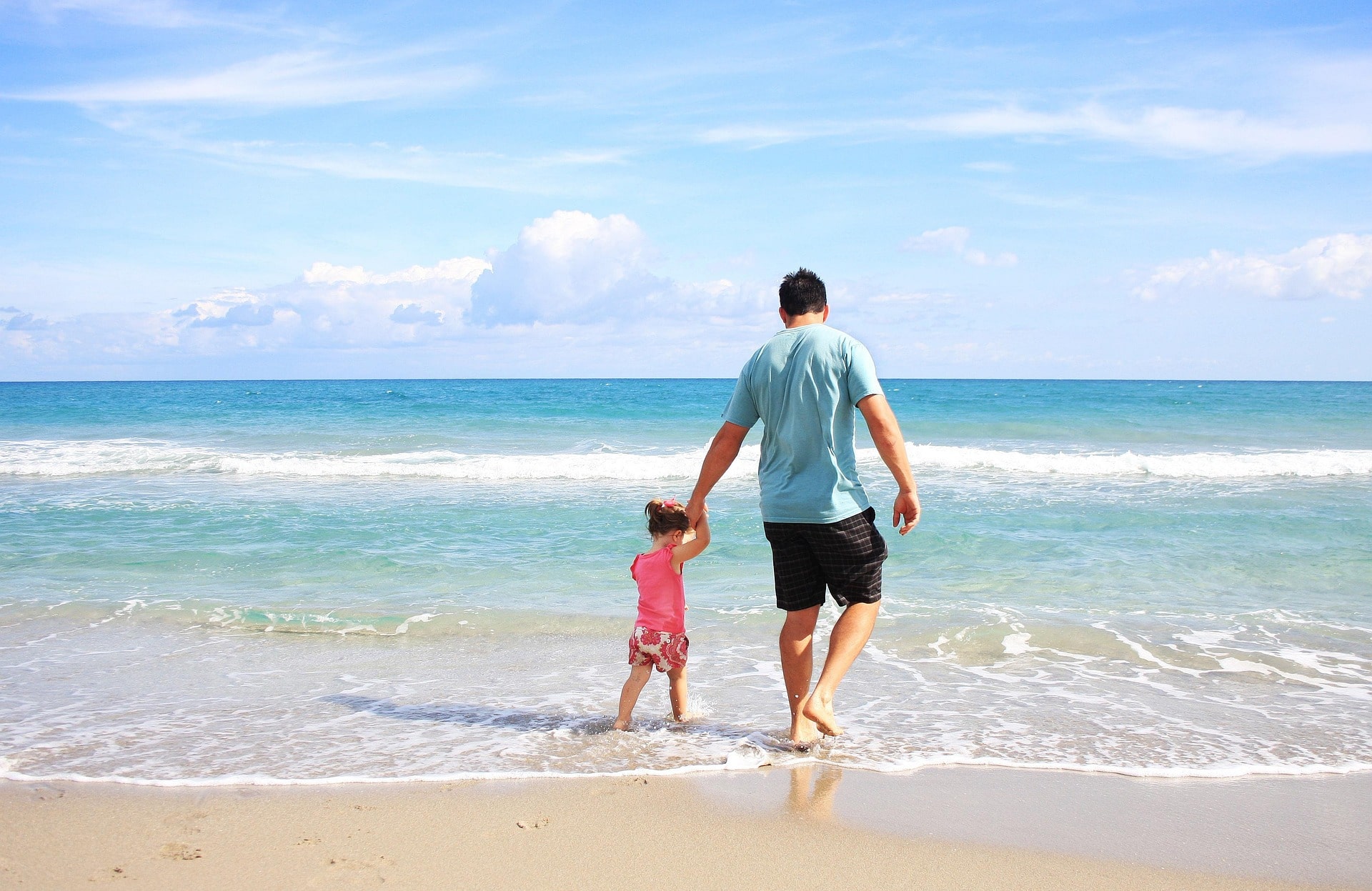 Foto zeigt einen Vater mit seinem Kind am Meer