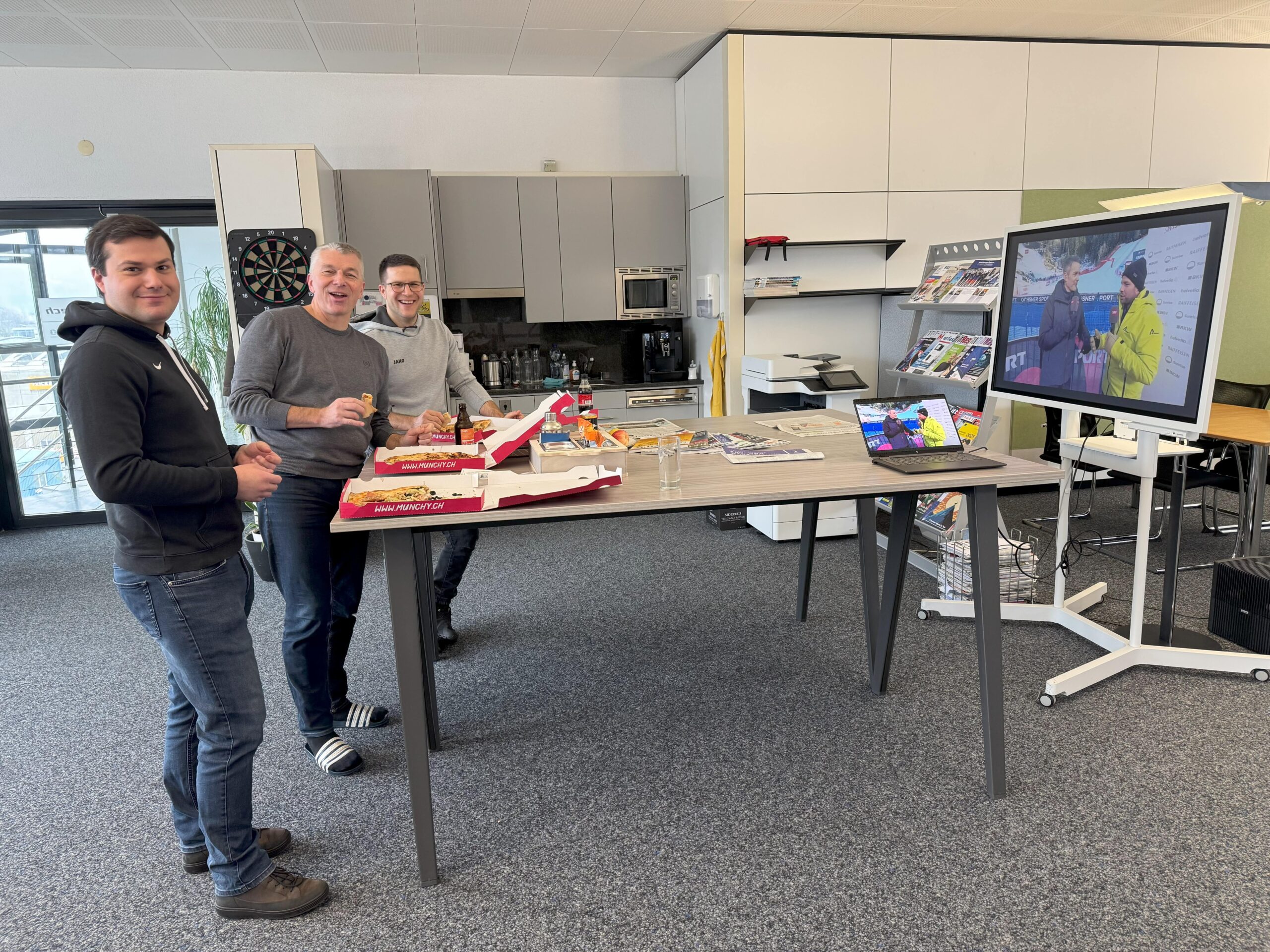 Mitarbeiter schauen Skirennen in der Mittagspause