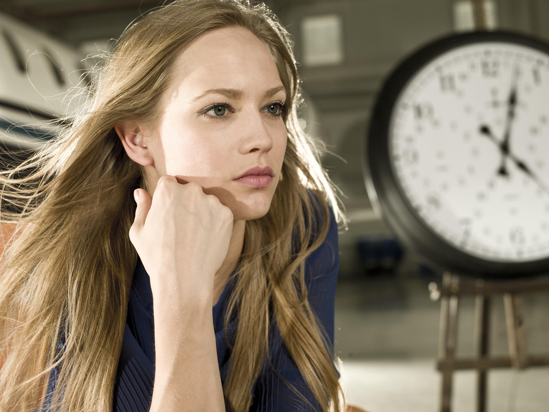 Foto von einer Frau mit einer Uhr im Hintergrund